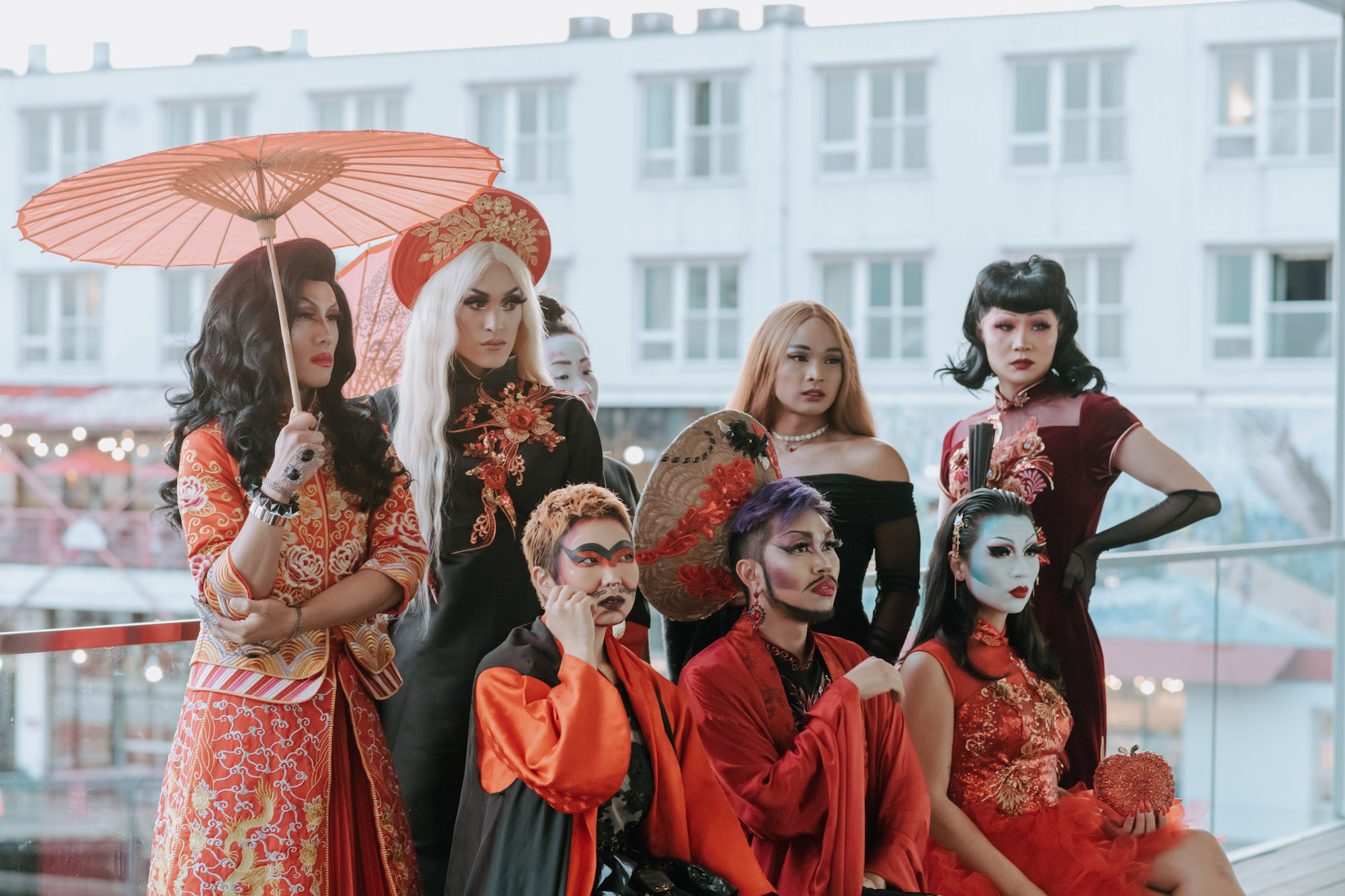 Eight members of House of Rice, dressed in red and black, pose on the terrace of the Polygon Gallery.