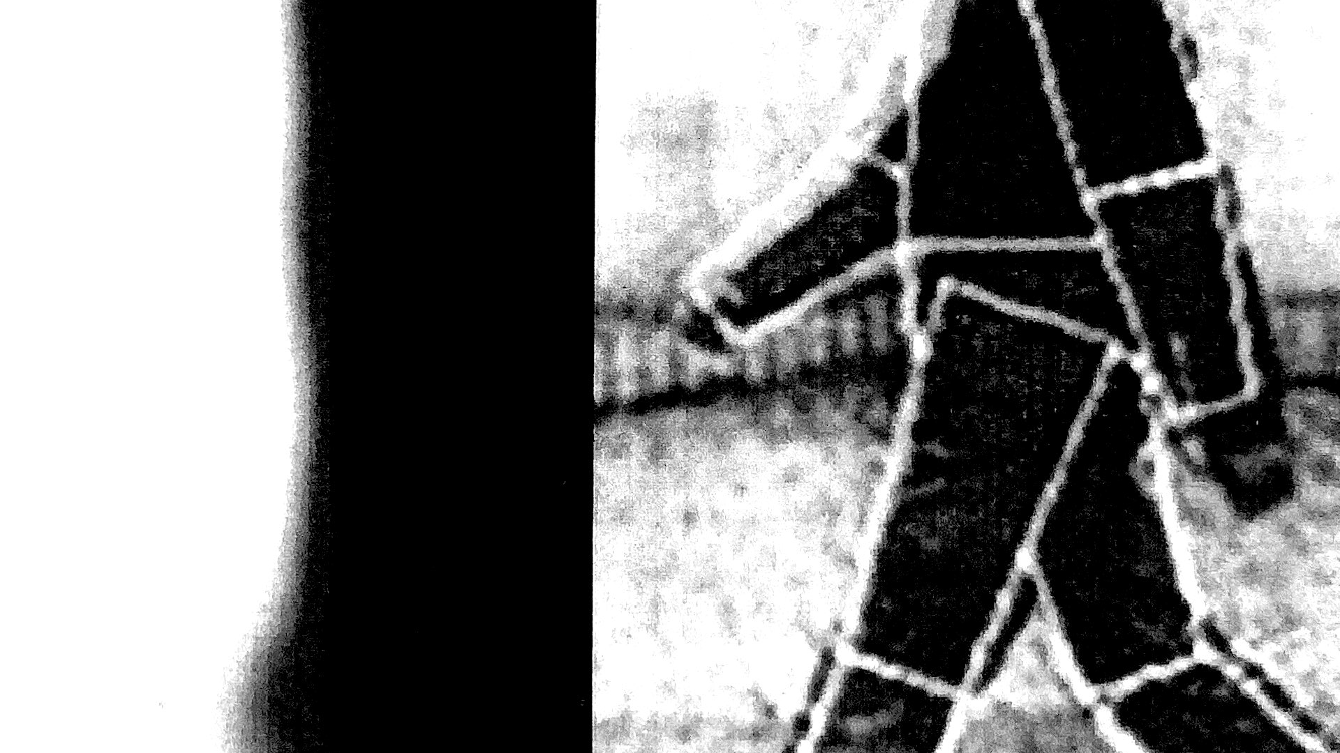 A black-and-white distorted image featuring a boxy figure walking towards the left.